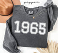 Gray (pepper) sweatshirt with '1965' printed on it, worn by a person, with a plain background.
