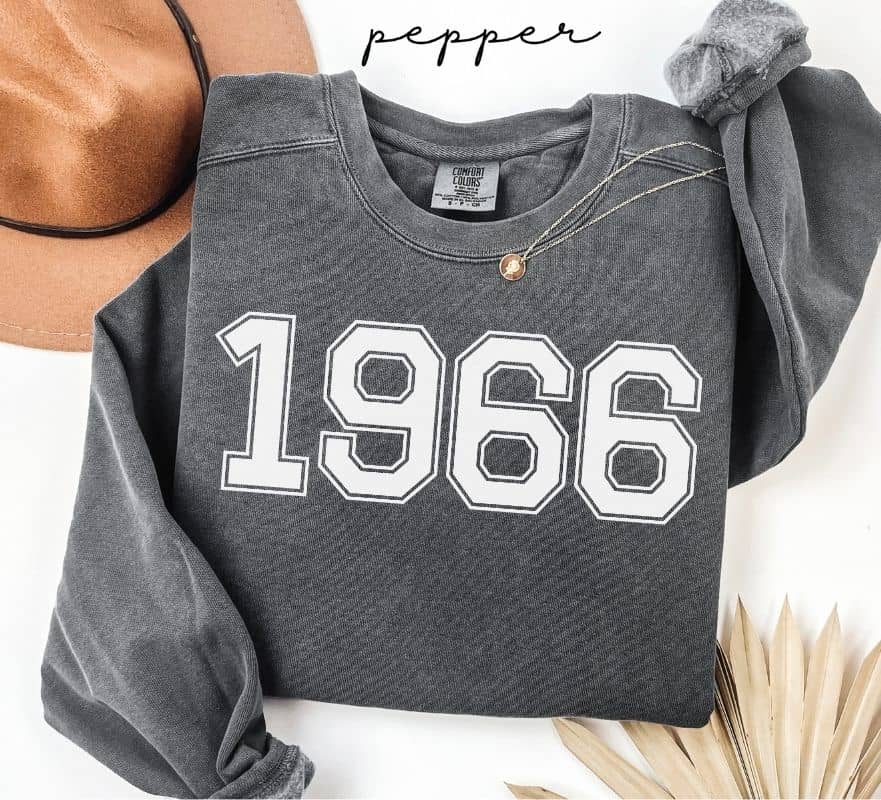 Gray (pepper) sweatshirt with '1966' printed on it, worn by a person, with a plain background.
