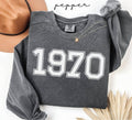 Gray (pepper) sweatshirt with '1970' printed on it, worn by a person, with a plain background.