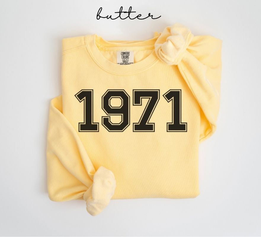 Yellow (butter) sweatshirt with '1971' printed on it, folded and displayed against a white background.