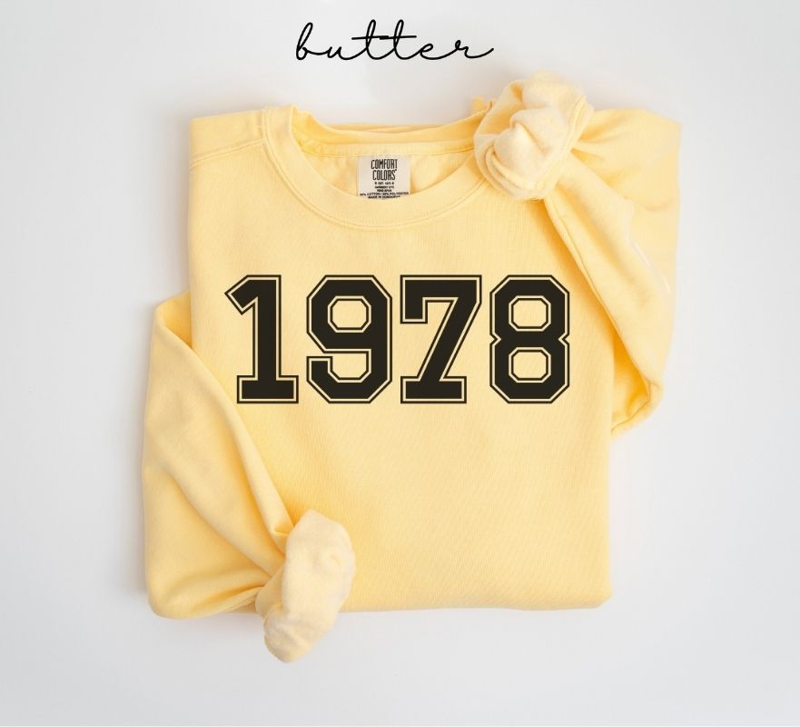 Yellow (butter) sweatshirt with '1978' printed on it, folded and displayed against a white background.