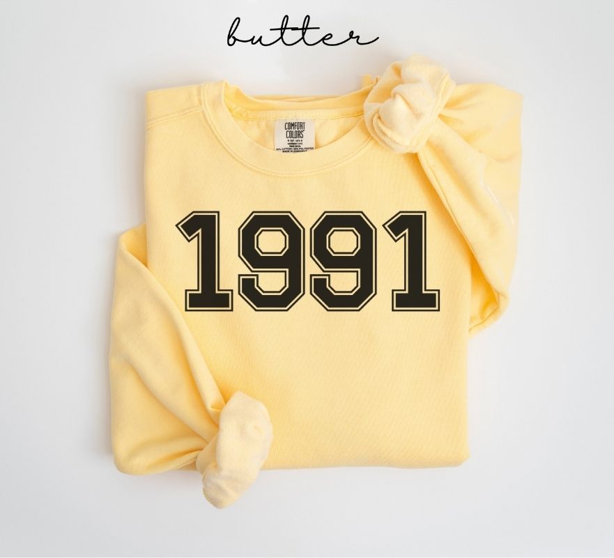 Yellow (butter) sweatshirt with '1991' printed on it, displayed on a light gray background.