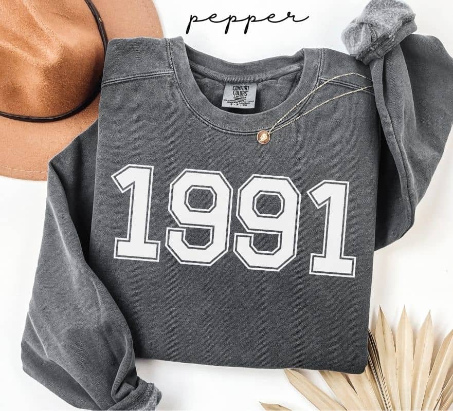 Gray (pepper) sweatshirt with '1991' printed on it, displayed against a neutral background.
