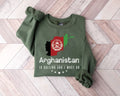 Military green sweatshirt with Afghanistan design on a wooden floor