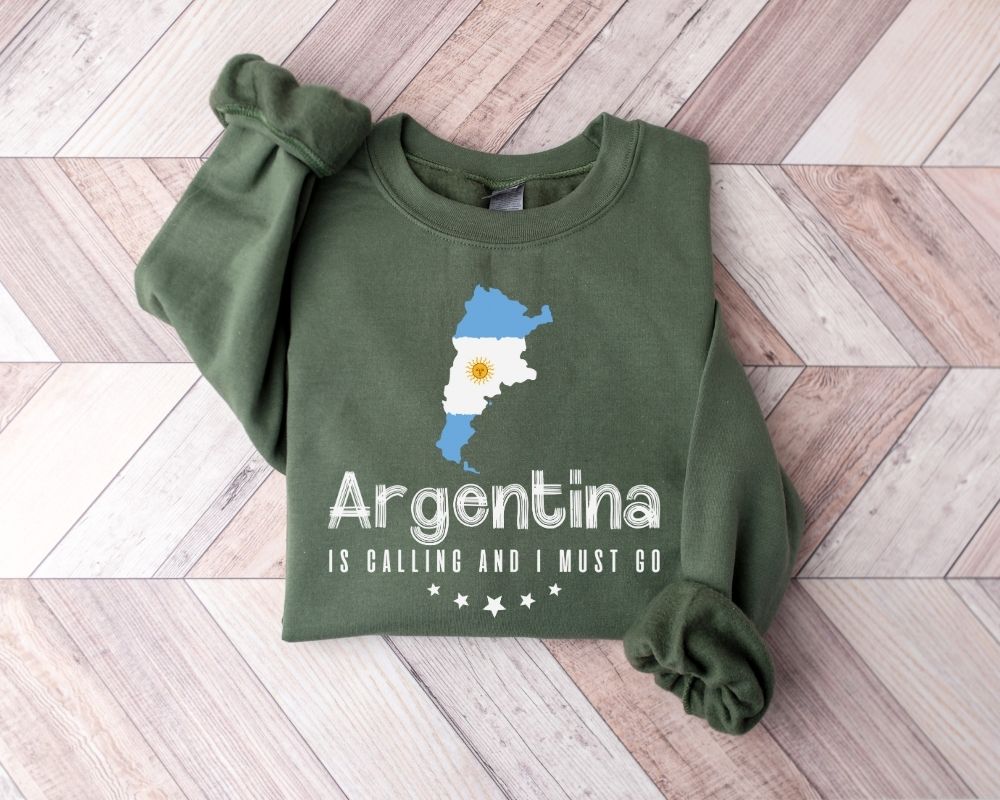 Military green sweatshirt with Argentina map and text on a wooden floor