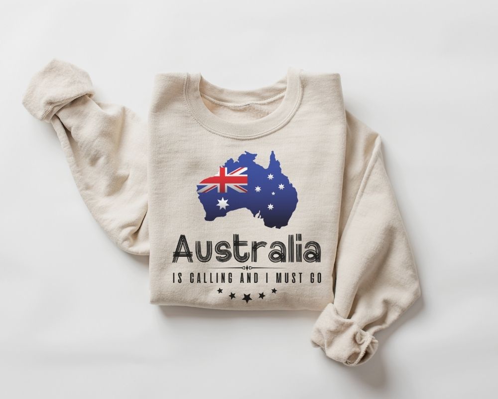 A beige (sand) sweatshirt featuring a design of the Australia map and flag on a white background.