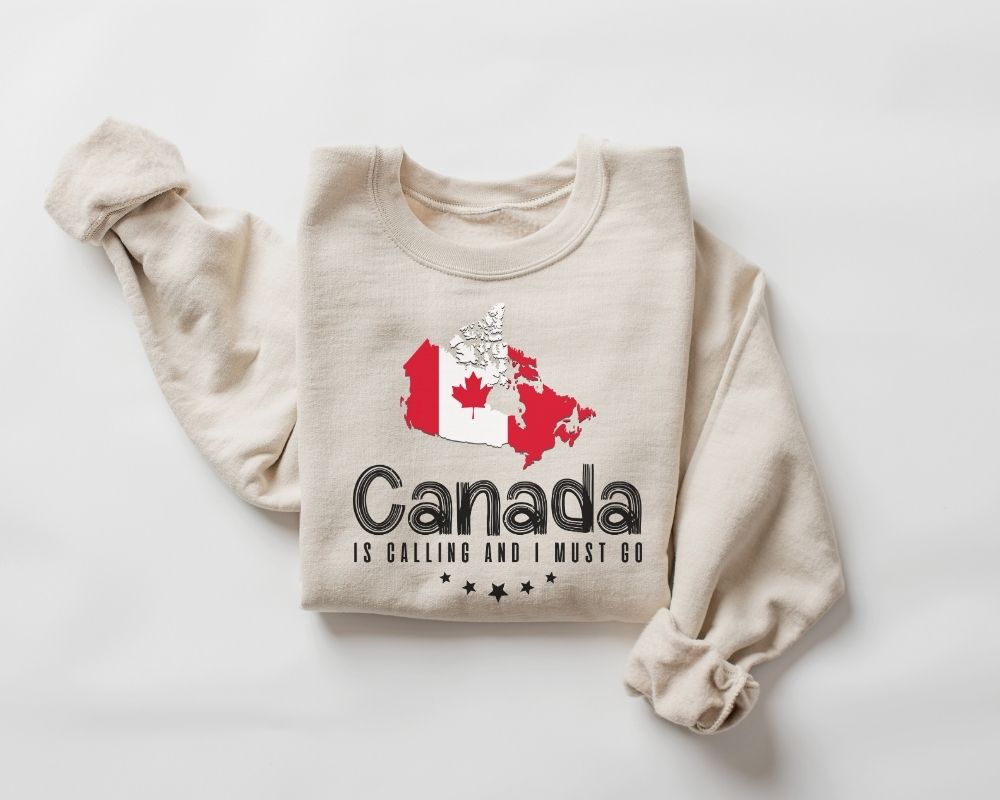 Beige (sand) sweatshirt with the Canadian flag and text on a white background.
