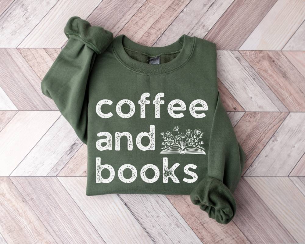Military green sweatshirt with 'coffee and books' text on a wooden floor