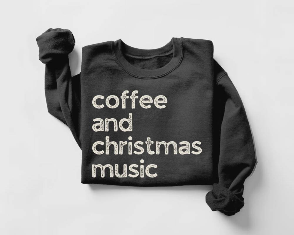 Black sweatshirt with 'coffee and christmas music' text on a light gray background
