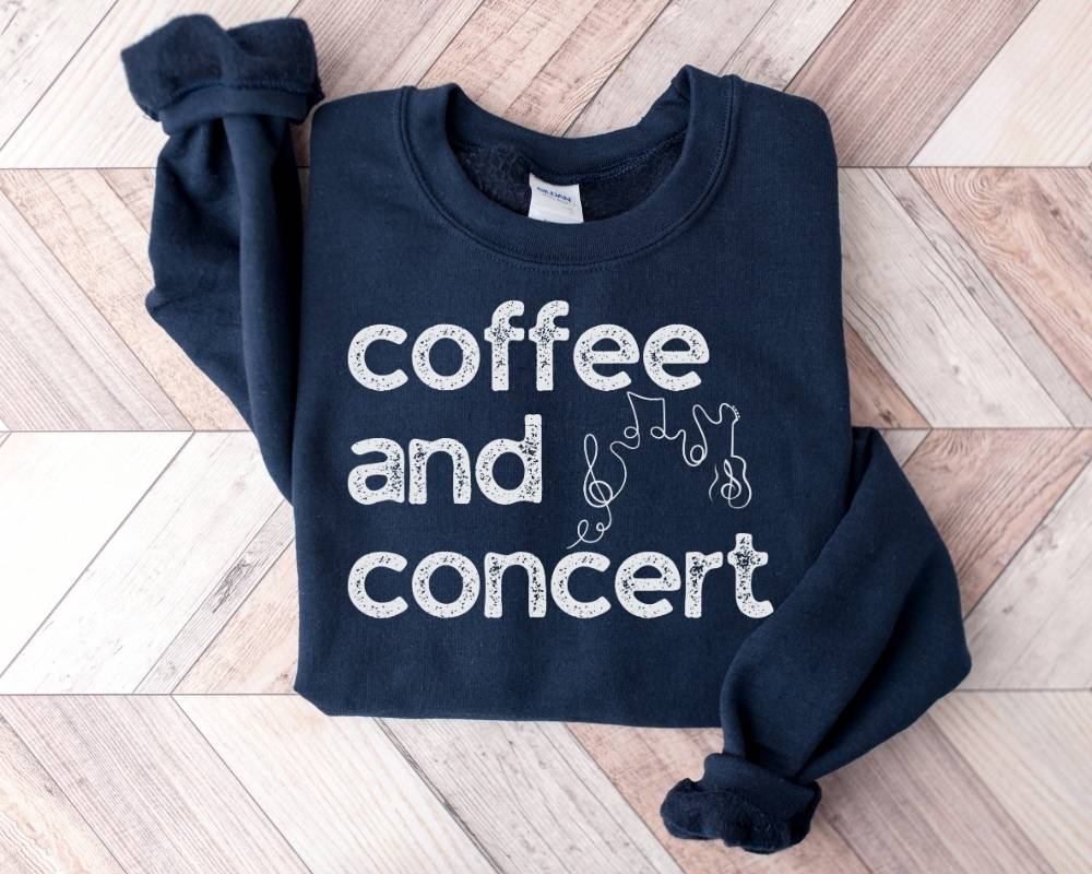 Navy blue sweatshirt with 'coffee and concert' text on a wooden floor