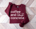 Maroon sweatshirt with 'coffee and concrete' and a cement mixer graphic on a wooden floor.