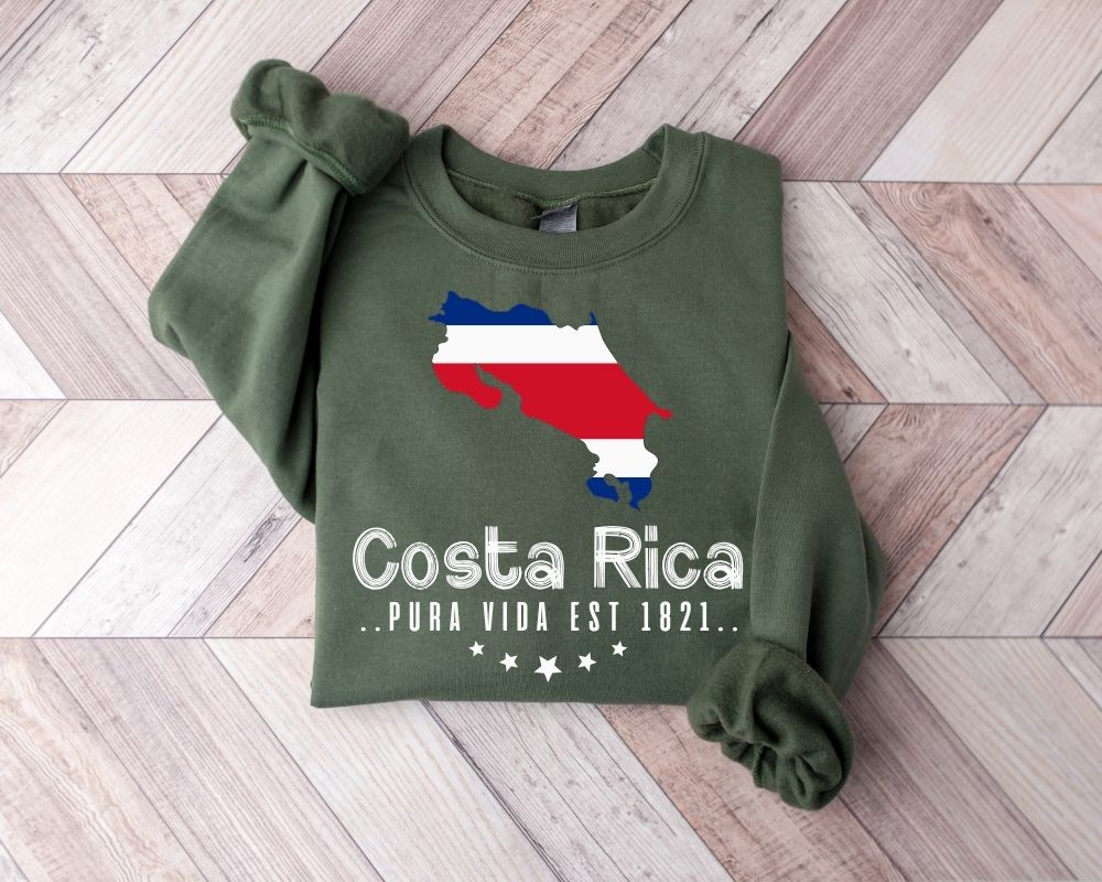 A millitray green sweatshirt featuring a map of Costa Rica and text displayed on a wooden floor.