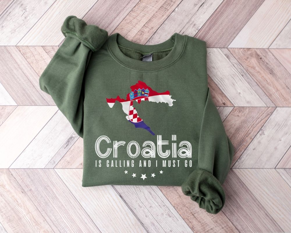 Military green sweatshirt with Croatia design on a wooden floor