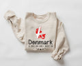 A beige (sand) sweatshirt featuring a Danish flag design along with text, all displayed on a white background.