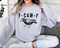 Person wearing a gray (ash) sweatshirt with a graphic design and text