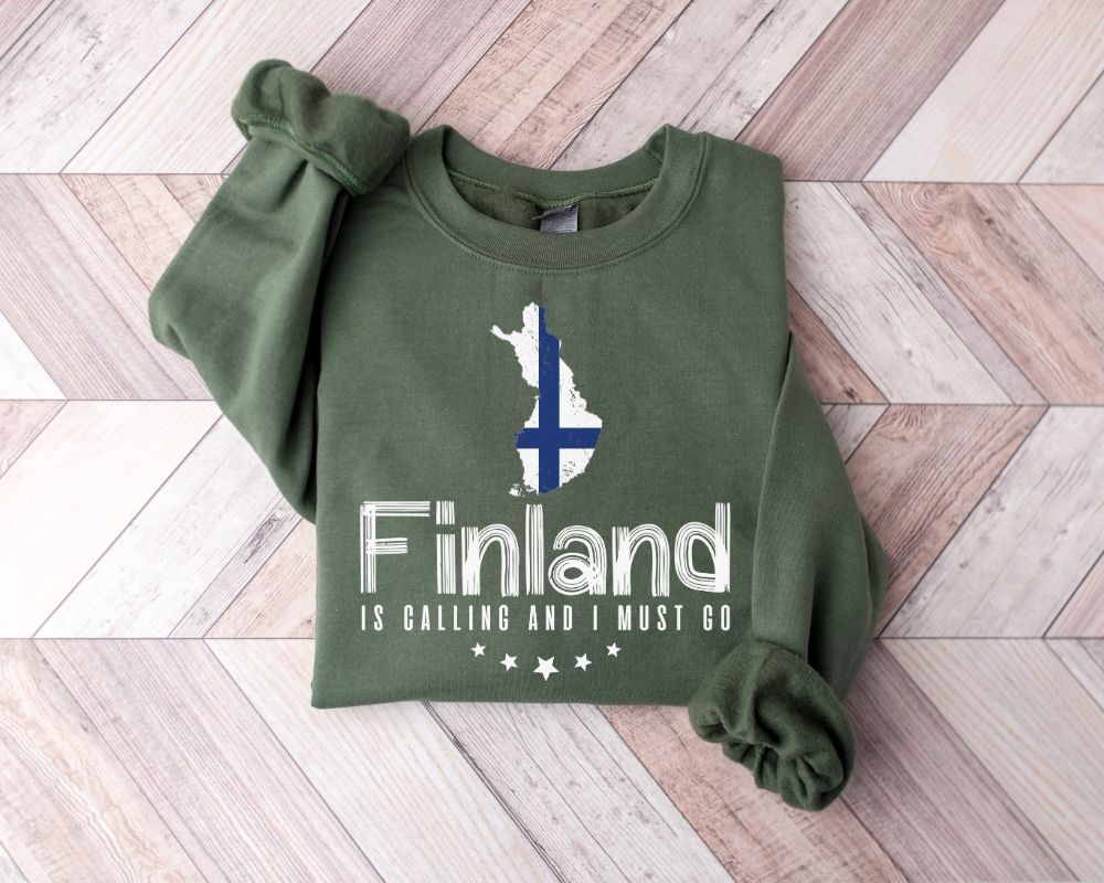 Military green sweatshirt with Finland design on a wooden floor