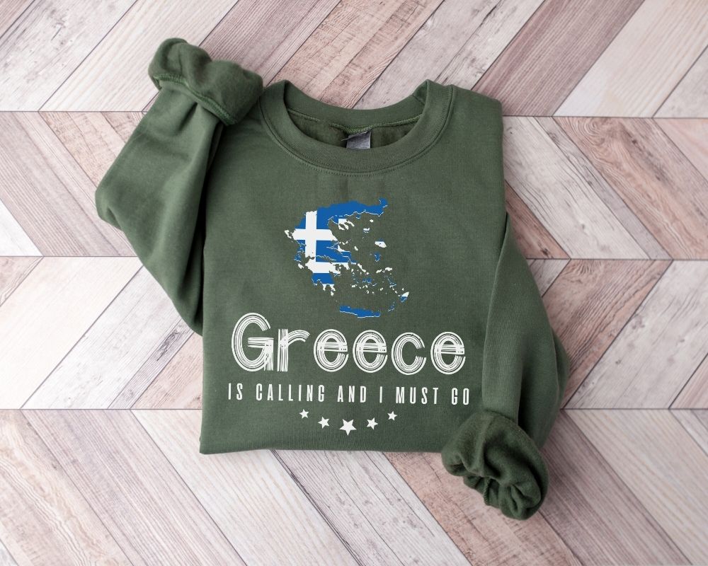 Military green sweatshirt with Greece map and text on a wooden floor