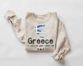 Beige (sand) sweatshirt with 'Greece is calling and I must go' text and Greek flag design on a white background