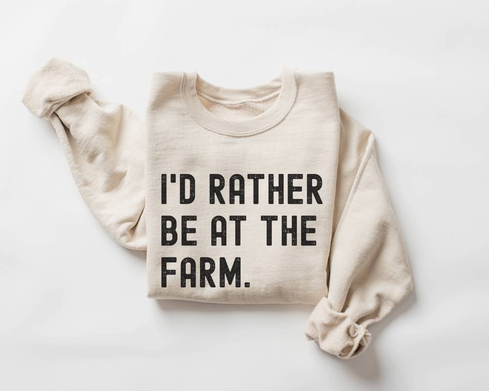 Beige (sand) sweatshirt with 'I'd Rather Be At The Farm' text on a white background