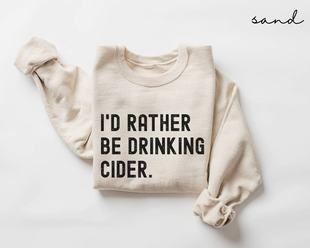 Beige (sand) sweatshirt with 'I'd rather be drinking cider' text on a white background