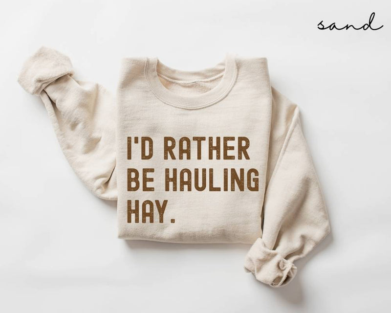 Beige (sand) sweatshirt with 'I'd Rather Be Hauling Hay' text on a white background