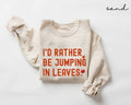 Beige (sand) sweatshirt with red text 'I'd rather be jumping in leaves' on a white background