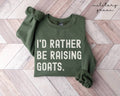 Military green sweatshirt with 'I'd Rather Be Raising Goats' text on a wooden floor.