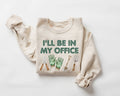 Beige (sand) sweatshirt with 'I'll be in my office' text and gardening tools on a white background