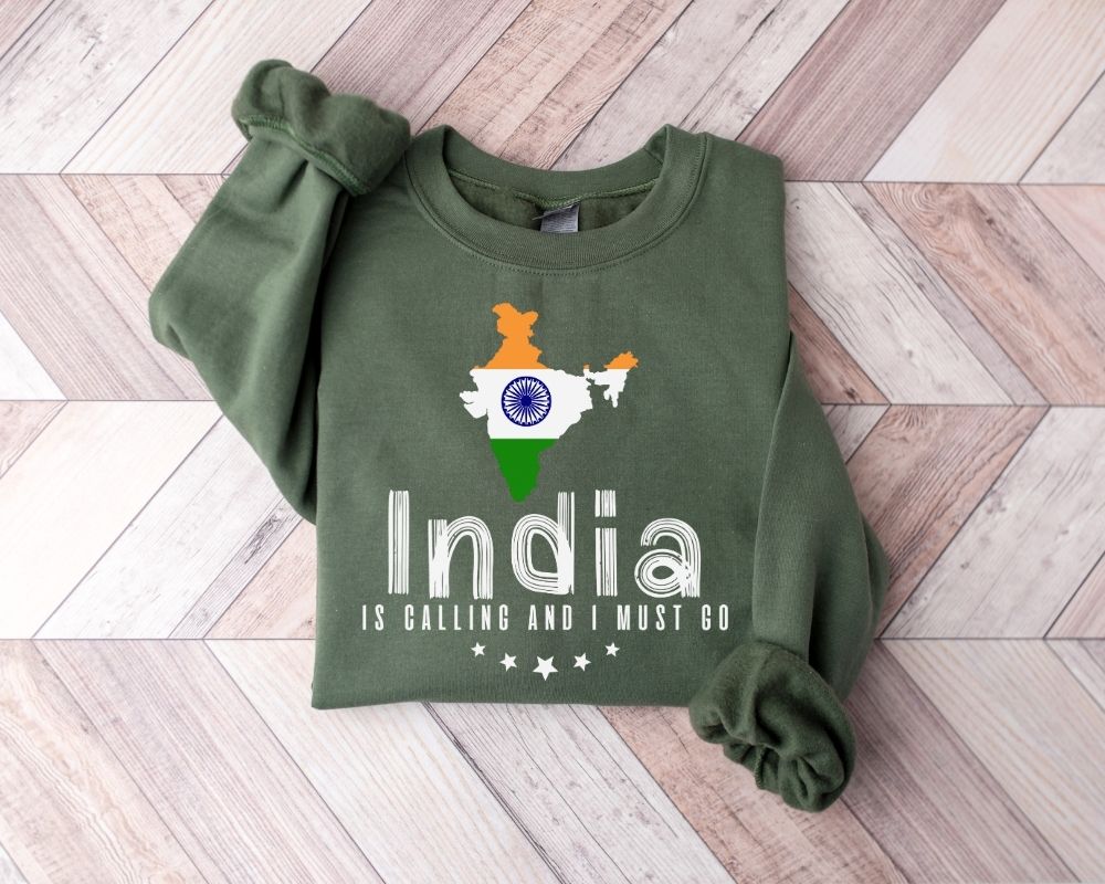 Military green sweatshirt with 'India is calling and I must go' text and flag design on a wooden floor.