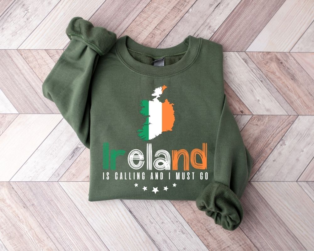 Military green sweatshirt with Irish flag design and text on a wooden floor