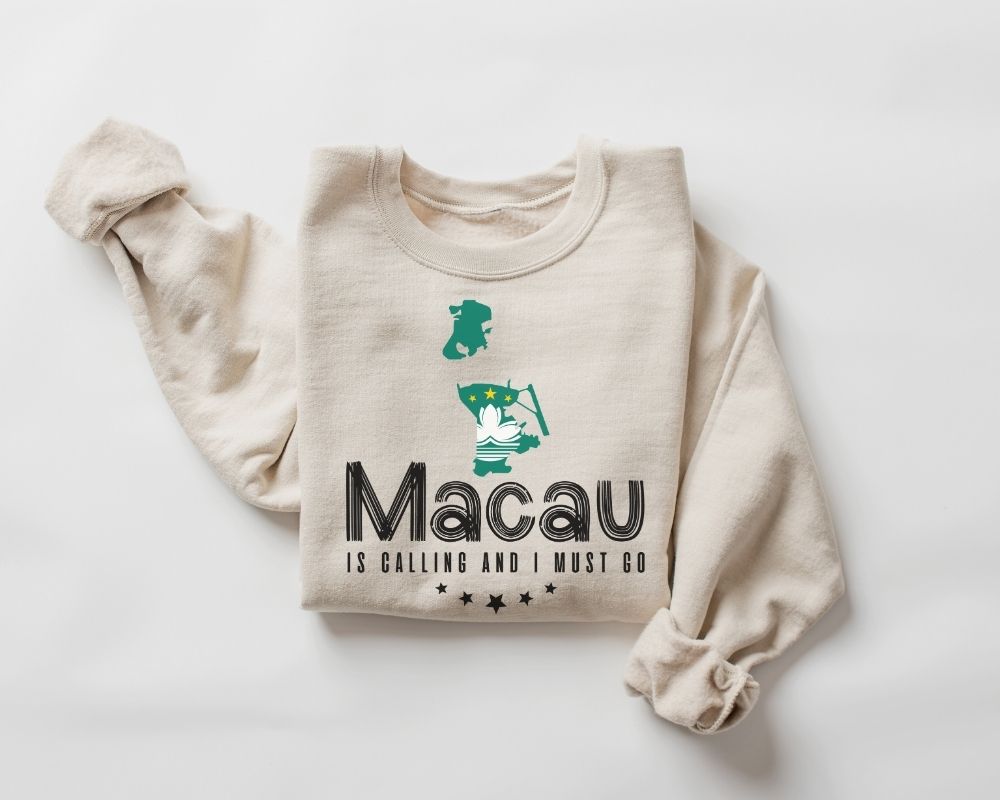 Beige (sand) sweatshirt featuring the text 'Macau is Calling and I Must Go' along with a graphic on a white background.