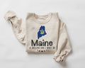 Beige (sand) sweatshirt with Maine state outline and text on a white background