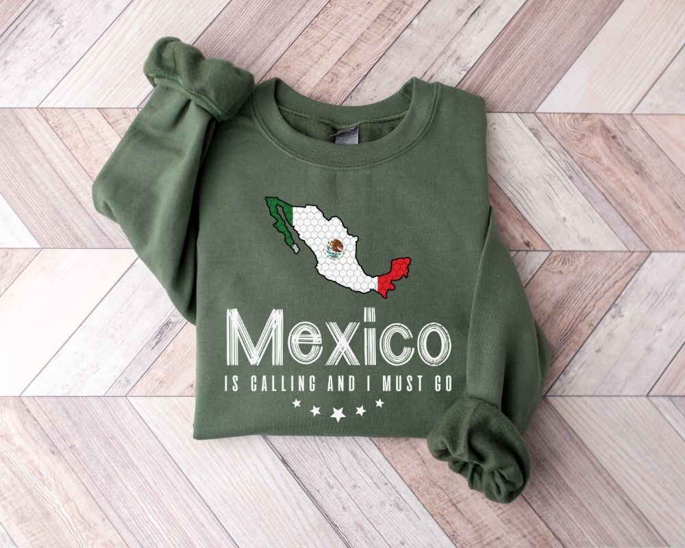 Military green sweatshirt with Mexico design and text on a wooden floor