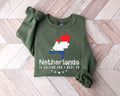 Military green sweatshirt with Netherlands design on a wooden floor