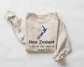 Beige (sand) sweatshirt with New Zealand design and text on a white background