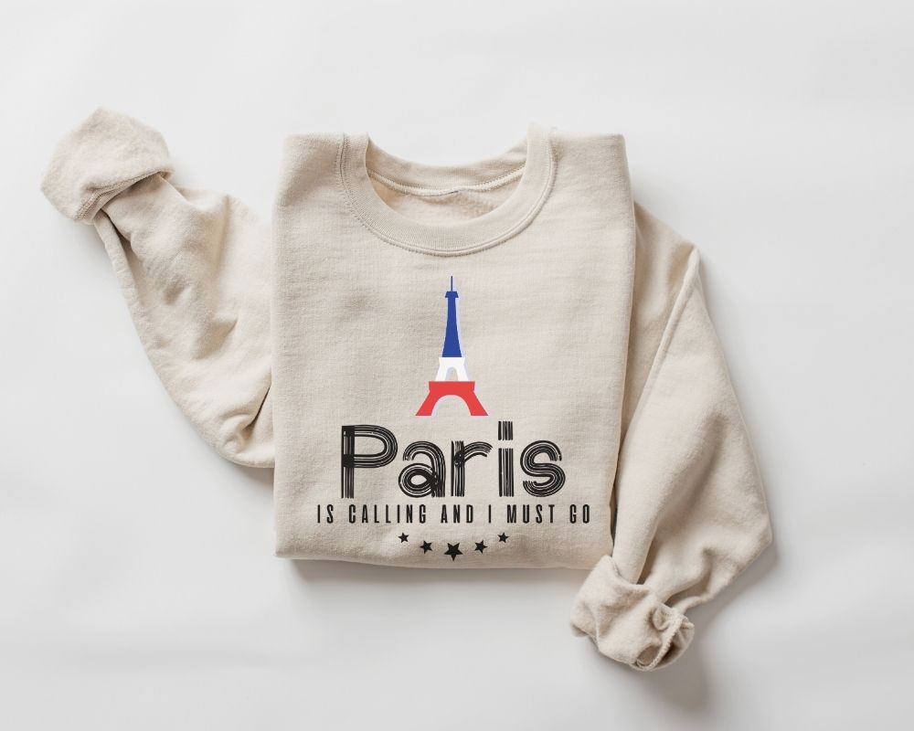 Beige (sand) sweatshirt featuring a Paris-themed design on a white background.