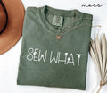 Folded green (moss) t-shirt with 'SEW WHAT' text on a white background