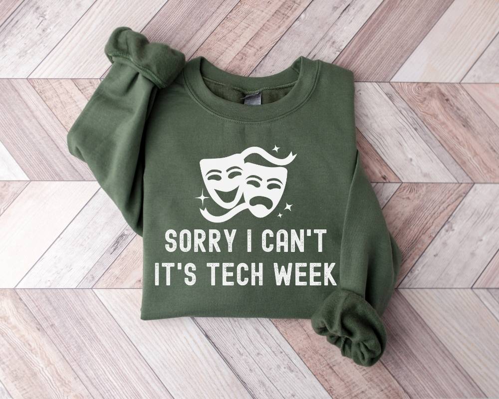Military green sweatshirt with a graphic and text on a wooden floor