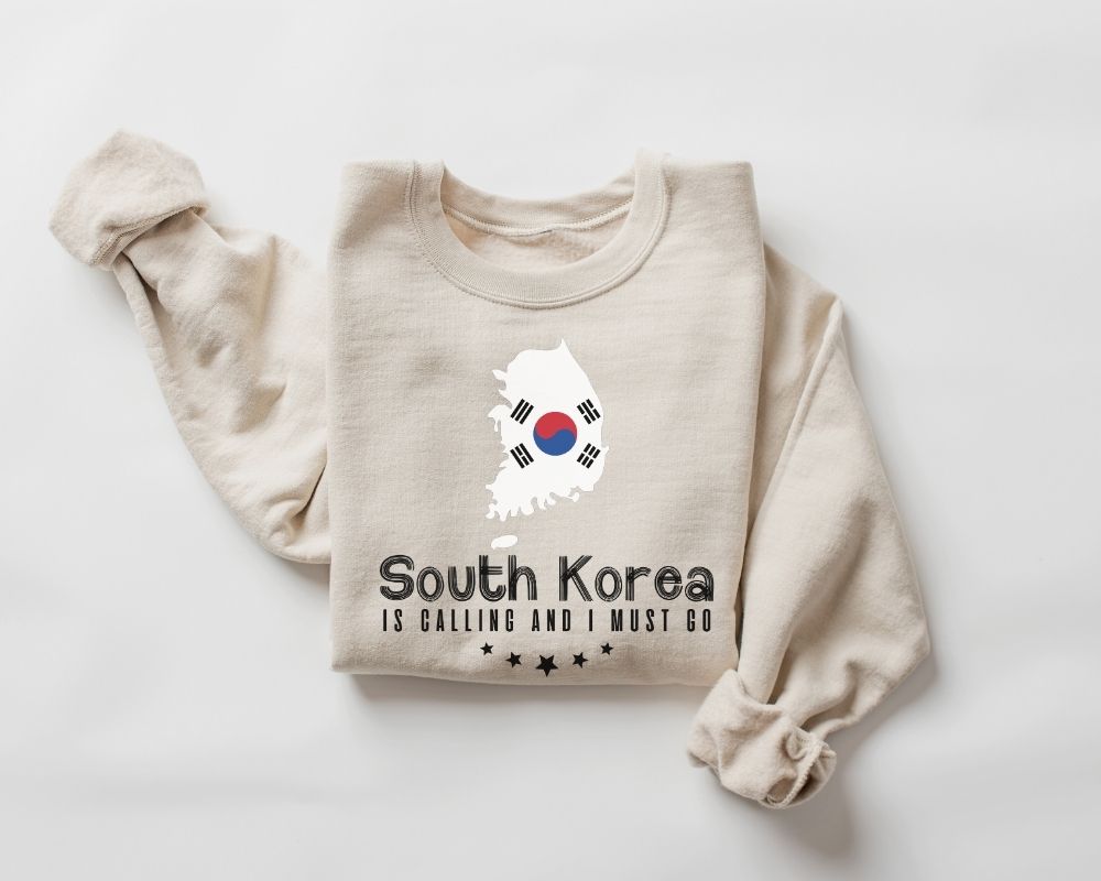 A beige (sand) sweatshirt featuring a South Korea design and text on a white background.