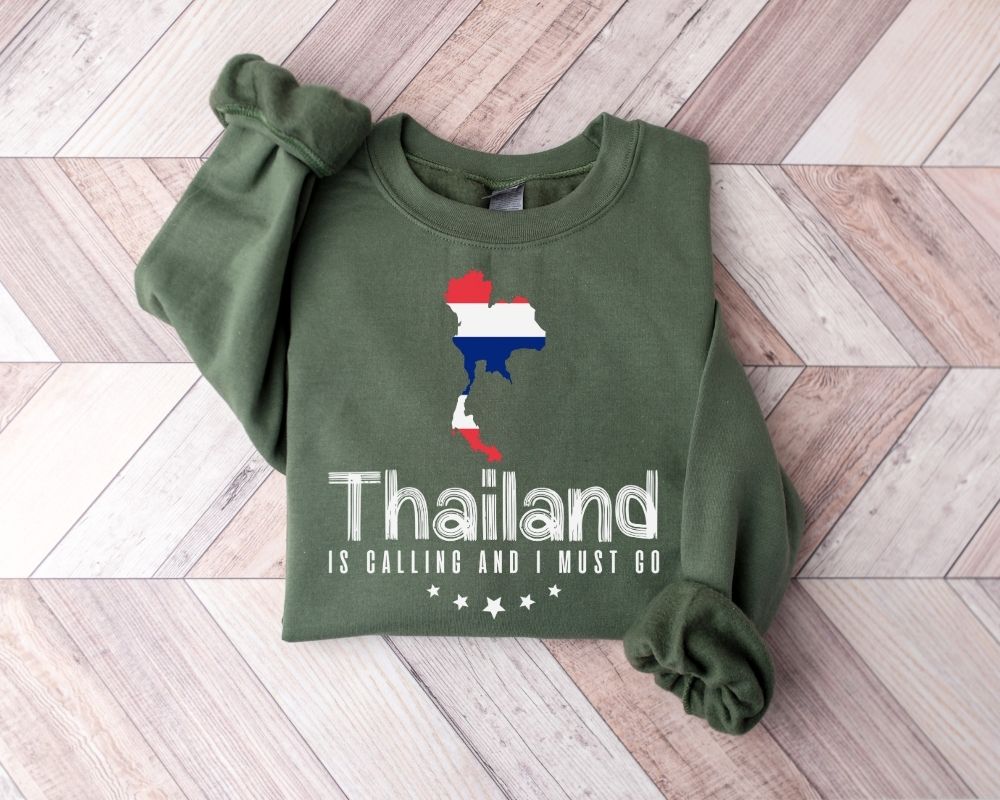 Military green sweatshirt with Thailand map and text on a wooden floor