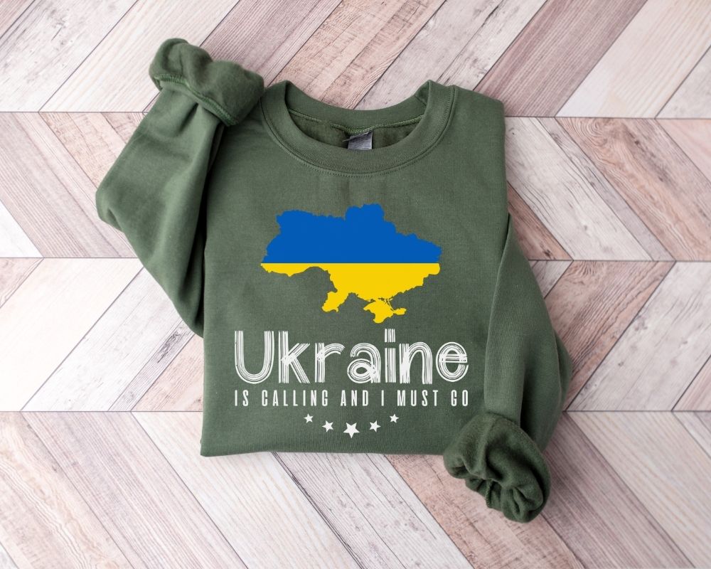 Military green sweatshirt with Ukraine map design on a wooden floor