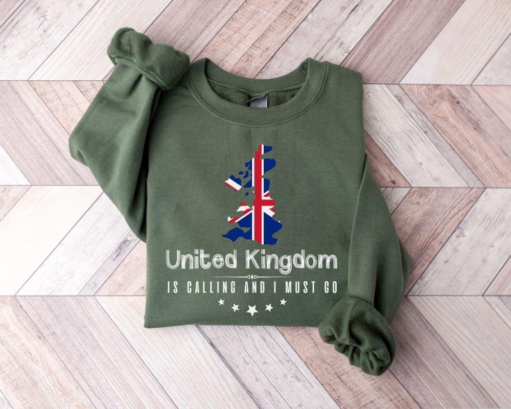 A millitray green sweatshirt featuring a UK design and text, placed on a wooden floor.