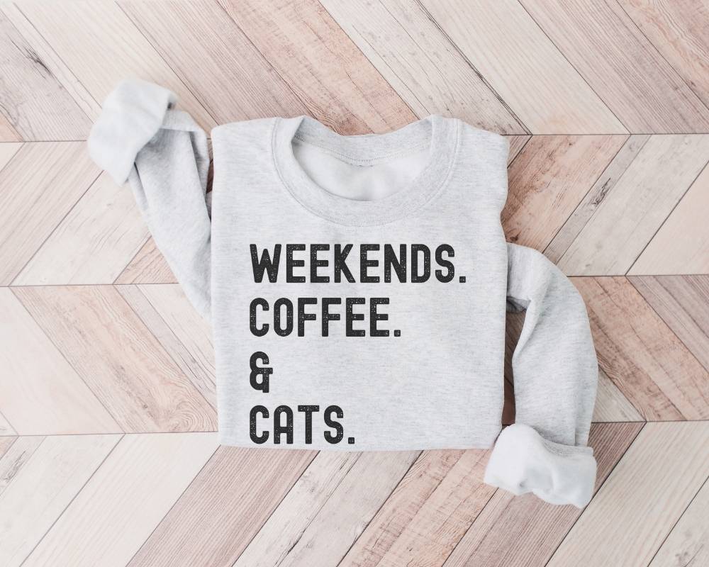 Gray (ash) sweatshirt with 'Weekends. Coffee. & Cats.' text on a wooden floor